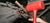 A person installing a yoke on a vehicle using a red mallet.